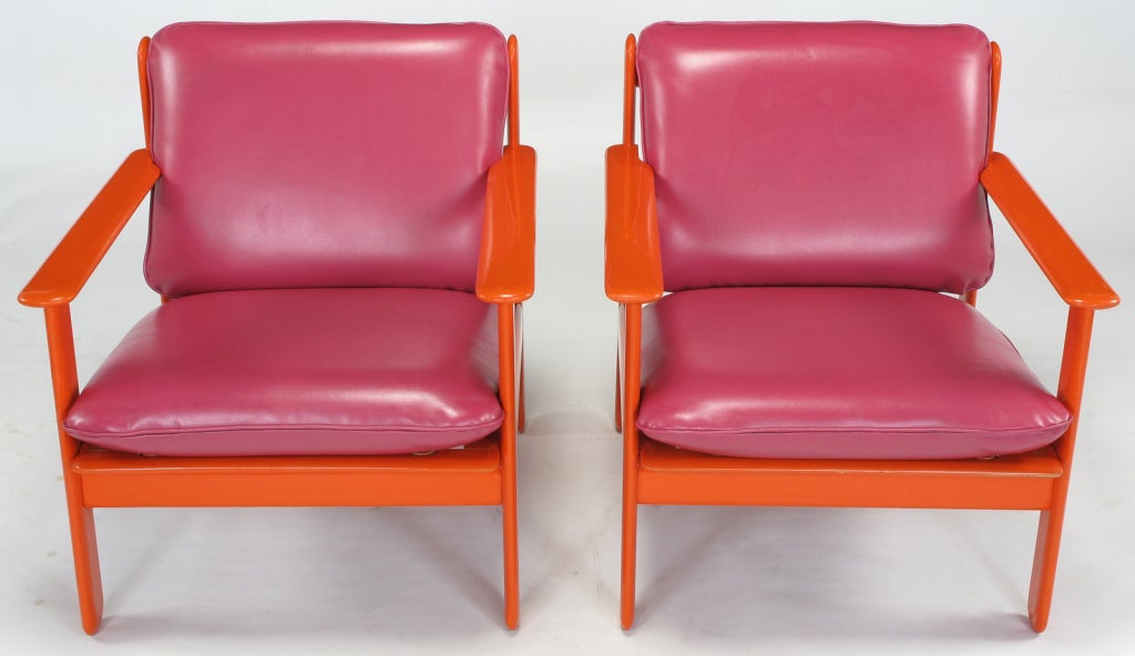 Colorful pair of Italian lounge chairs with persimmon orange lacquer over wood frames and magenta red-pink simulated leather seats and backs. Possibly a design offered by Stendig from the Memphis period of Italian furniture.