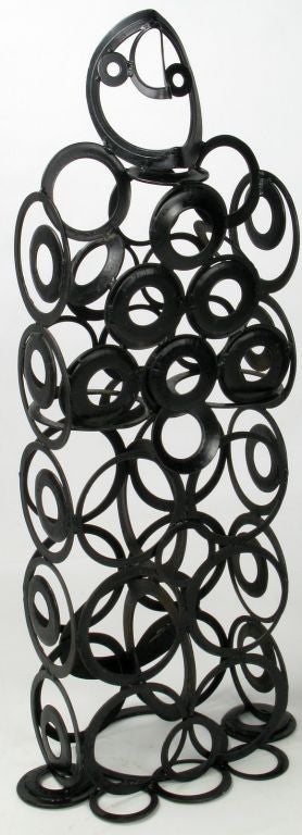 Stylized human form sculpture of welded steel eccentric circles, finished in black paint. Could be used indoors, or in the garden.