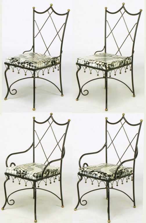Set of four black wrought iron indoor or outdoor dining chairs with brass ball and bell details with psychedelic black, grey and off white harlequin vinyl seats. Triple peak 