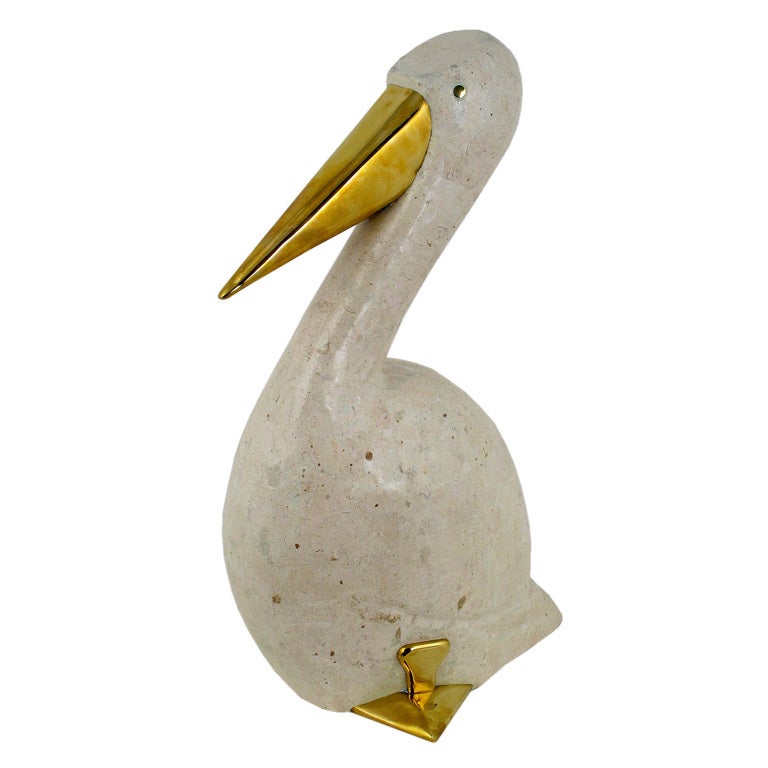 Sculptural and slightly primitive, this stylized pelican is clad in tessellated fossil stone. The beak and feet are wrapped in brass. Fabricated in the Philippines, as were many tessellated stone pieces of Karl Springer and Maitland Smith.