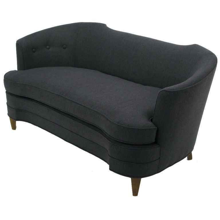 Beautifully sculpted settee freshly reupholsered in charcoal wool felt. Evocative of the Edward Wormley Oasis Sofa, designed for Dunbar. Clean lined walnut legs and the compact size make it perfect for a bedroom or large foyer.