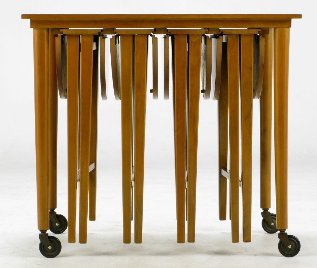 Clearly inspired by the set that Ms. Schaefer designed for M. Singer & Sons in 1952, for which she won a Good Design award. Four folding dropleaf tables slide into tracks under the top of the largest of the set, an end table, which is mounted atop