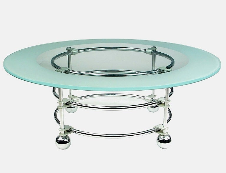 An uncommon Jay Spectre round coffee table for Century Furniture. The Chromed steel base is held together with cast aluminum U-brackets. Spherical feet, also in chrome. One-half inch thick glass top is clear with a wide acid etched border.