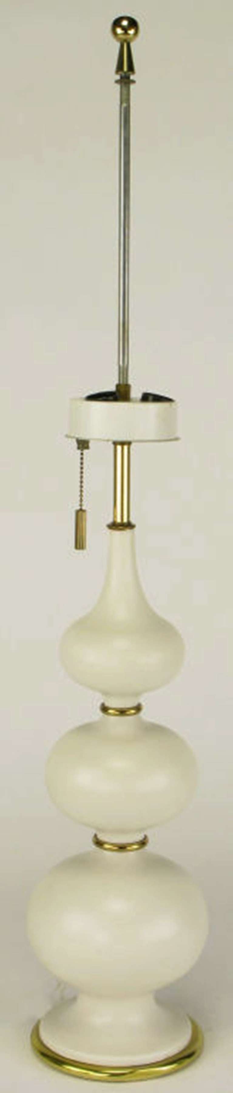 Stunning Lightolier table lamp in white satin glazed ceramic stacked spherical bodies. Each segment separated by a brass ring spacer. Base is a brass plate. The three socket lighting element with pull chain is original. Sold sans shade.

 