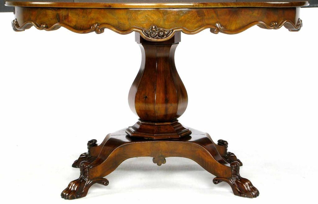 Elegant and exquisitely carved Italian dining table with paw foot quadruped base. Beautiful scalloped edge skirting with foliate detail. Could also be used as a center table.