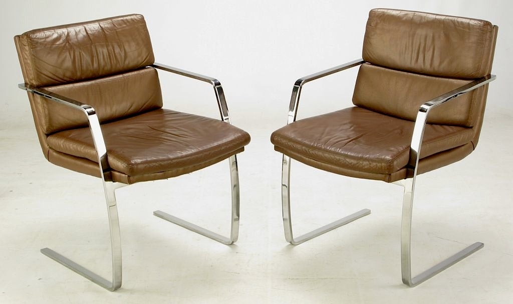 Pace Collection chrome flat bar and mocha leather arm chairs. Superior build quality with heavy chrome-plated flat bar cantilevered frame. Retaining their original leather upholstery, these striking chairs work in a variety of applications.