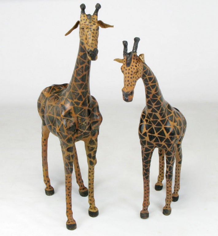 Realistic miniature models of a pair of mother and daughter giraffes made from wood, wire and plaster frames and wrapped in dyed patterned and form fitting leather. Wonderful details from the antlers to the glass eyes to the tails.
Smaller giraffe