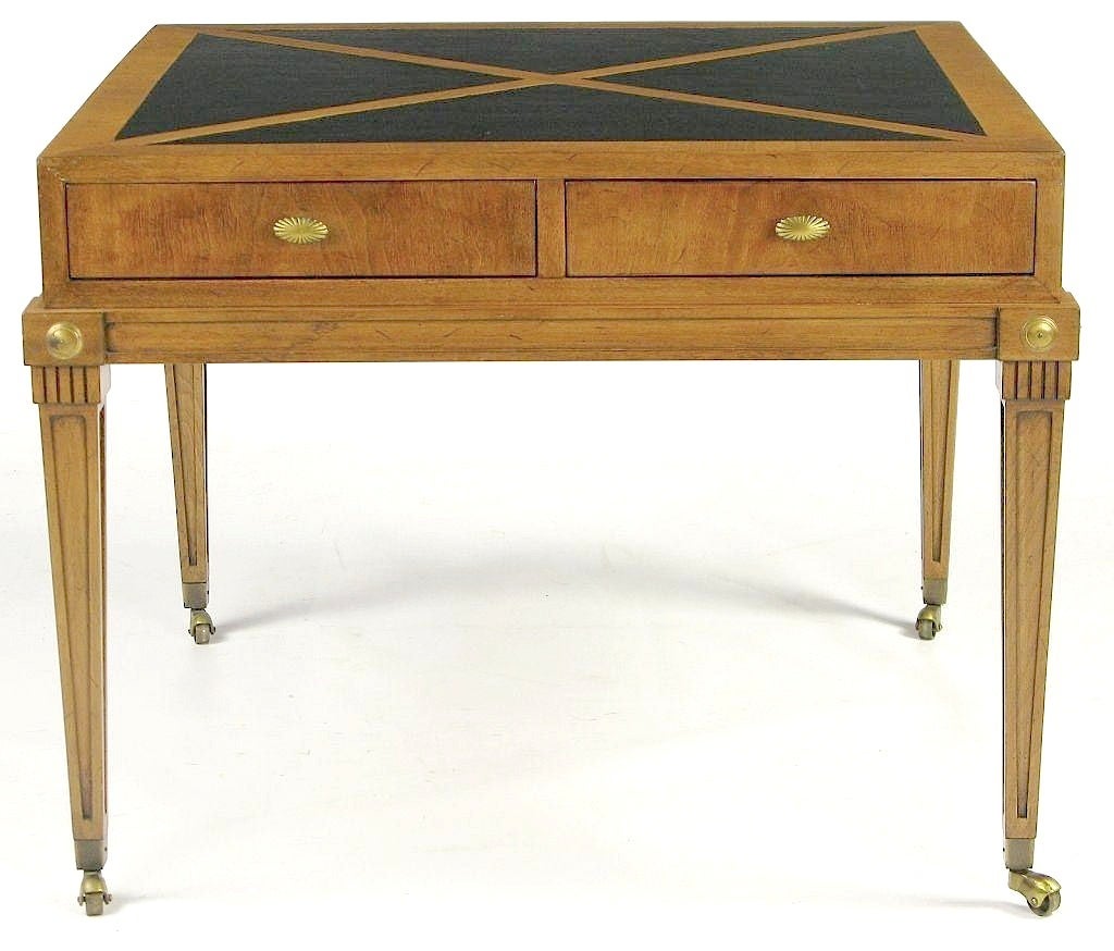 Renzo Rutili for Johnson Furniture empire style end table in walnut and black leather. Brass rosettes to each corner and brass casters to each leg. Inlaid black leather parquetry top creates an X pattern. Pair of drawers with oval brass sunburst