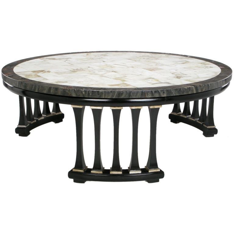 Elegant ebonized and silver leafed coffee table with a three balustrade base sections, creating a colonnaded effect. The top is a wonderful heavily veined marble, in grays, whites,and blacks, with a parquetry pattern.