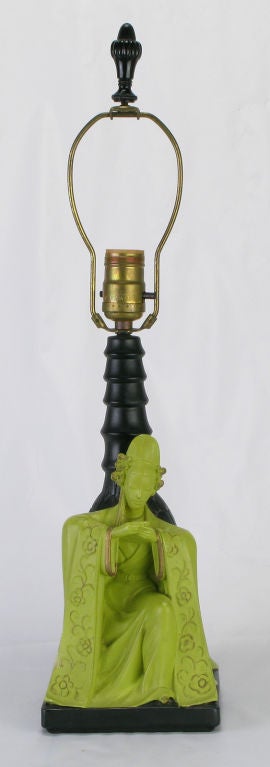 Pair of chartreuse green and parcel gilt ceramic table lamps in the manner of James Mont. Asian characters in ceremonial dress kneeling on black ceramic plinths with black ceramic bamboo form stems. Sold sans shades