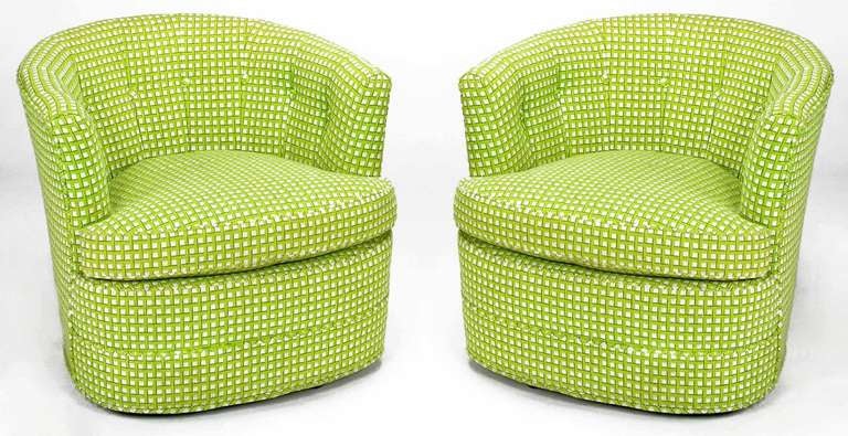 A striking pair of barrel back chairs in the original button tufted, wool needlepoint fabric. Strikingly upholstered in a vivid geometric chartreuse, green, gold and white. Low swivel mechanism is nearly fully concealed, making the chairs appear as