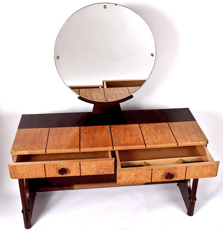 Striking Art Deco vanity constructed of dark mahogany and lighter burl, by the fine Danish furniture maker, Robert Rasmussen. Darker strips inlaid in the burl, with leather wrapped footrest. Round mirror mounted on Curule base. Sans mirror, would