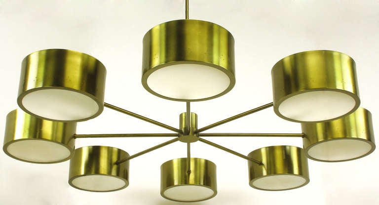 Very striking and uncommon chandeleir by Litecraft. Eight pierced and brass tone aluminum circular shades with white glass bottoms, are held in orbit around the center circular body and stem. Two available.