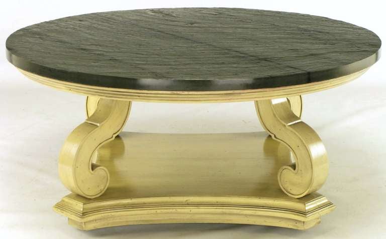 A Dorothy Draper design from her iconic Espana Collection, this exceptional Heritage Henredon round coffee table is comprised of hand carved wood with an ivory glaze. Reverse quatrefoil, canted corner base is on casters for ease in movement. Natural