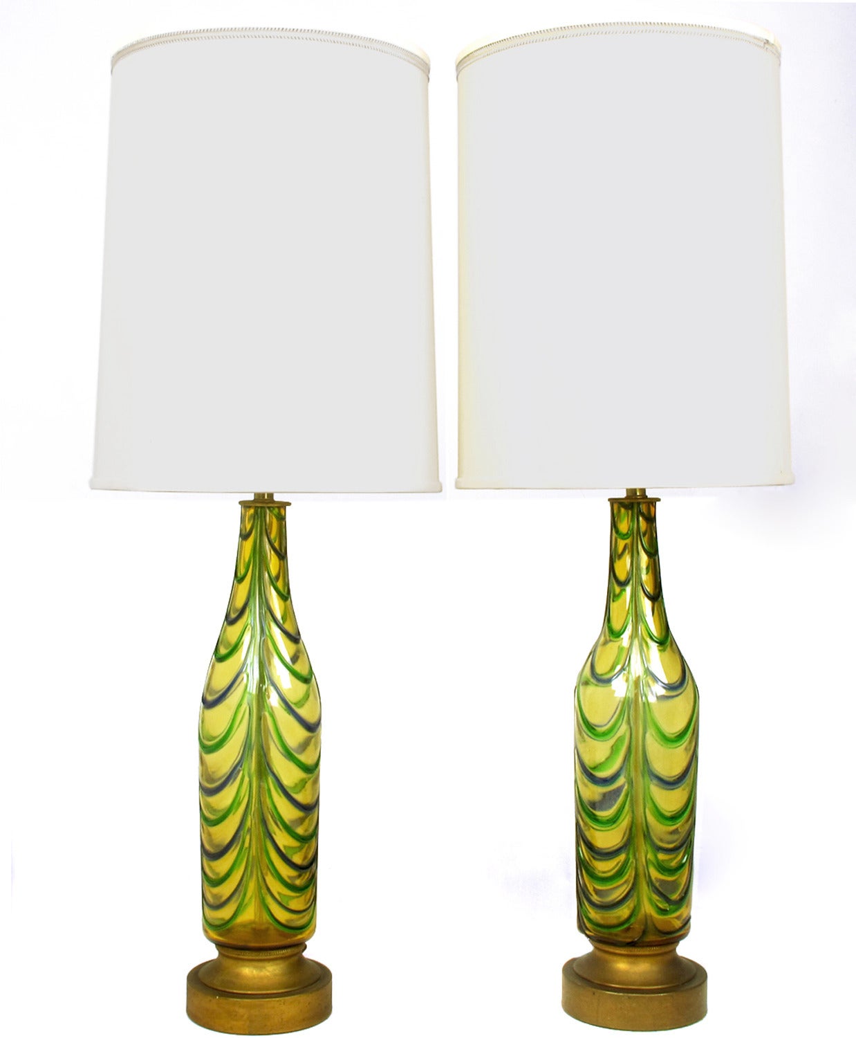 Fantastic pair of, most likely, Italian handblown glass bottle form table lamps. Primary glass color is saffron with alternating blue and green swagged ribs. Retrofitted with double socket clusters and rewired. Bases are gilt metal and have a slight