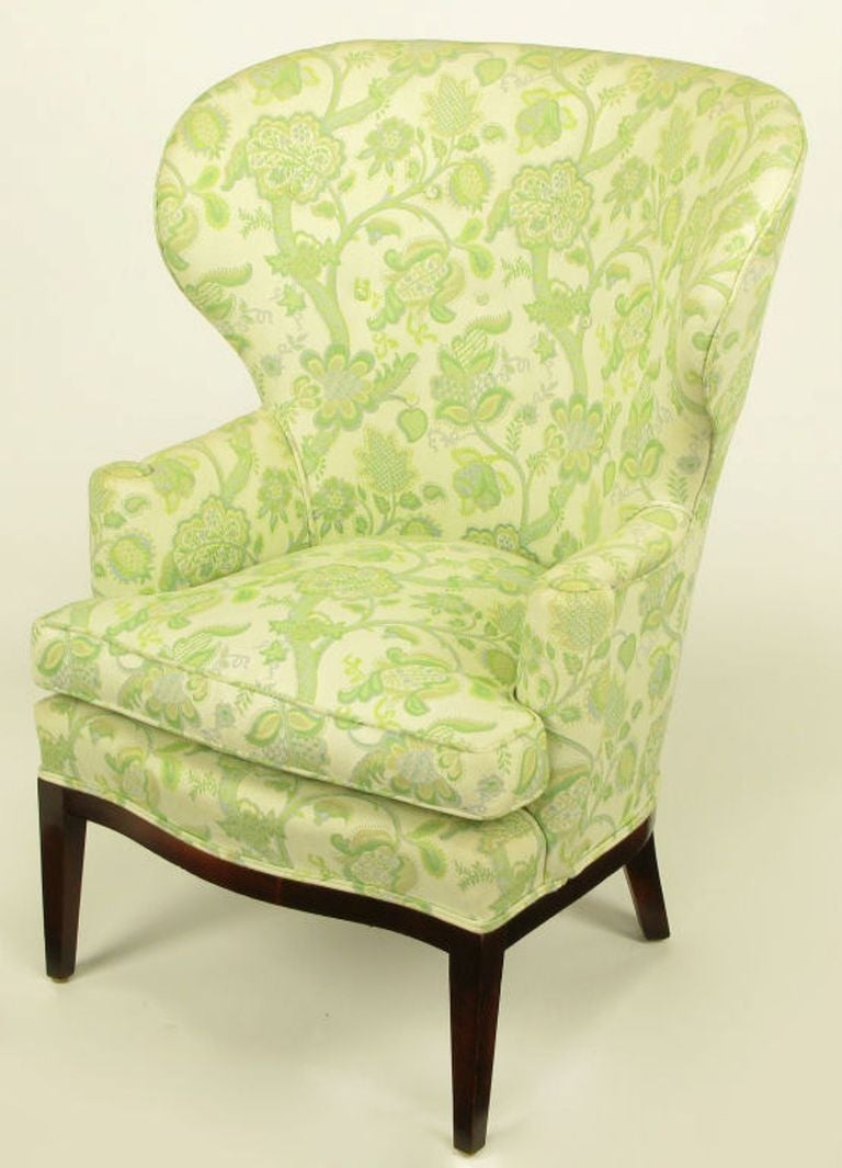 Uncommon wide wingback chair with a embroidered green, yellow and taupe linen upholstery. Simple clean line mahogany curved front apron and legs. A documented and very early Wormley design by Dunbar.

Pair availbale, COM.
