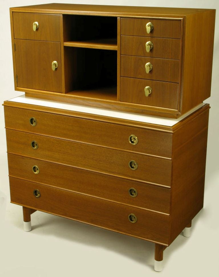 Renzo Rutili for Johnson Furniture tall two-tiered gentleman's chest. Mahogany cases and drawer/door fronts with a white Micarta first tier top and four white Micarta sabots over large dowel form legs supported by large side stretchers. Four lower