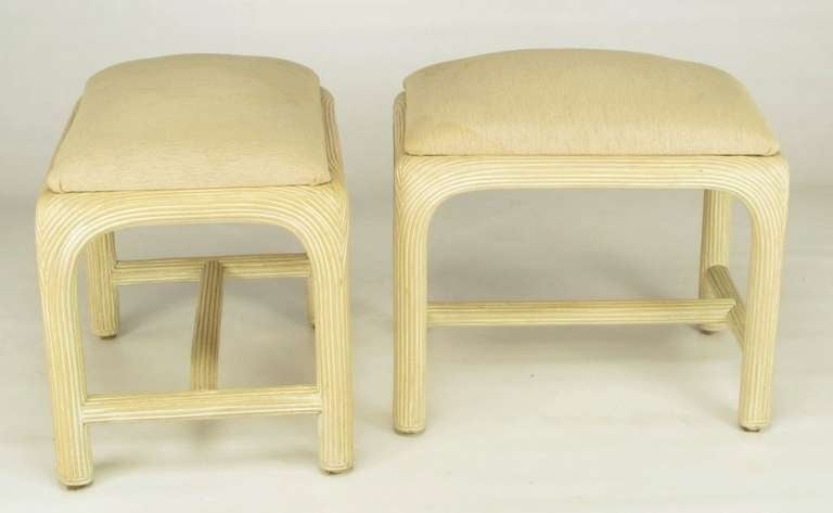 Pair of reeded rattan stools with radiused corners and ivory linen upholstered seats. Side and center stretchers and depth as well as support. Matching console is available in our listings.