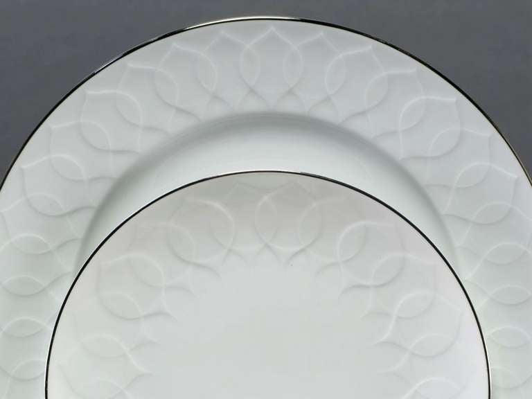 Designed by Bjorn Wiinblad in 1963 for Rosenthal China, Germany. Porcelain dinnerware service with 12 complete place settings, each including the dinner plate, soup bowl, salad plate, bread and butter plate, dessert bowl, coffee cup and saucer. Also