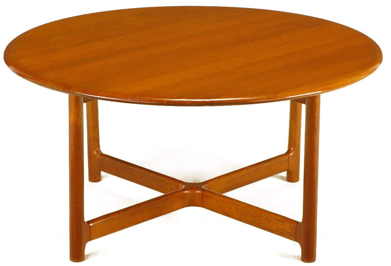 Solid teak wood coffee table manufactured by Norwegian cabinetmaker, Rasmus Solberg. Bull nose edge top, dowel style legs with a low carved X-stretcher.