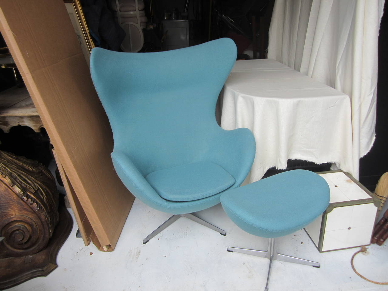 Arne Jacobsen's egg chair and ottoman designed for the SAS Royal Hotel and Air Terminal in Copenhagen. Fiberglass shell with foam padding, light blue polyester bouclé upholstery, set on aluminum base by Fritz Hansen.