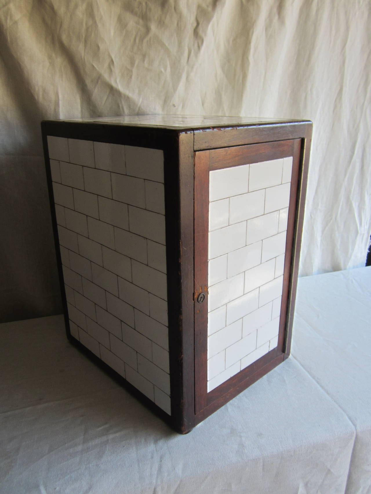 Wood framed porcelain faced humidor with milk glass lined interior with a glass shelf. There is no key.