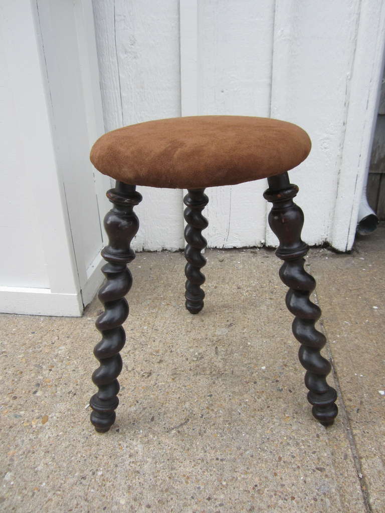 19th Century three-legged stool with a newly upholstered suede seat....