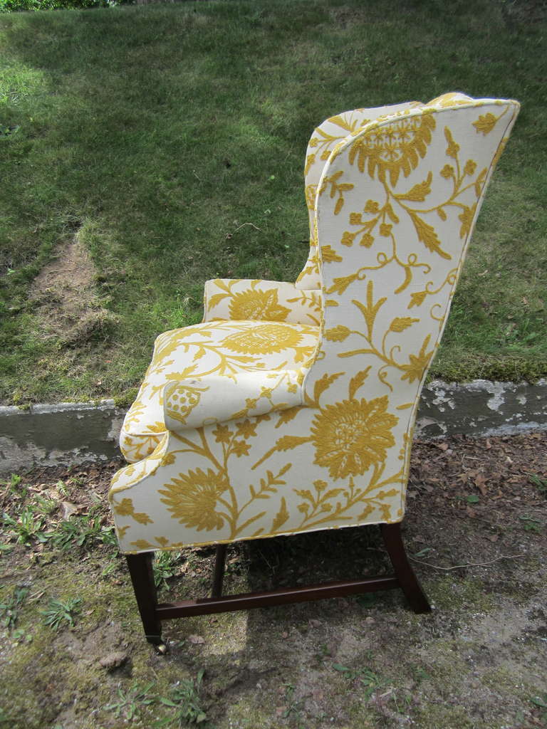Charming wing back chair in a slightly smaller scale, very difficult to come by.....in it's original crewel upholstery with down seat.....brass casters on the front legs.....