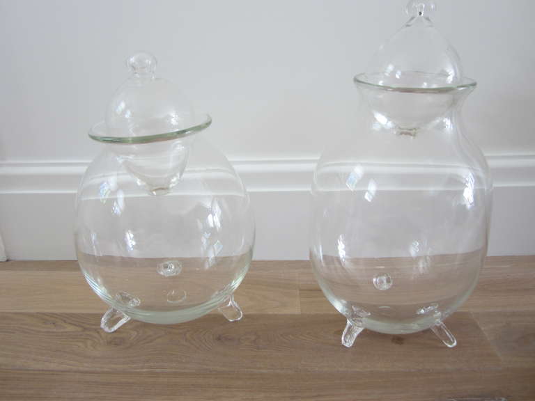 Whimsical art glass vessels with tripod bases and stoppers. All hand blown. Could be used as interesting vases or terrariums.