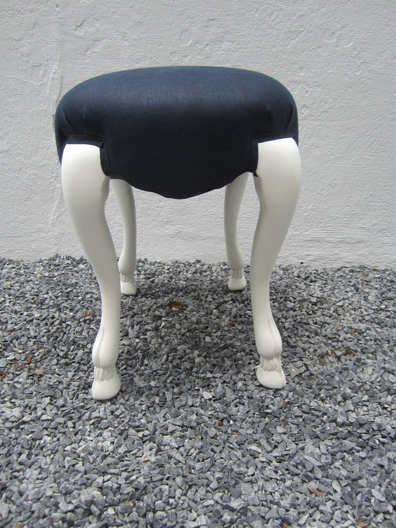 Whimsical goat leg stool in chalky plaster white finish and newly upholstered in navy linen....