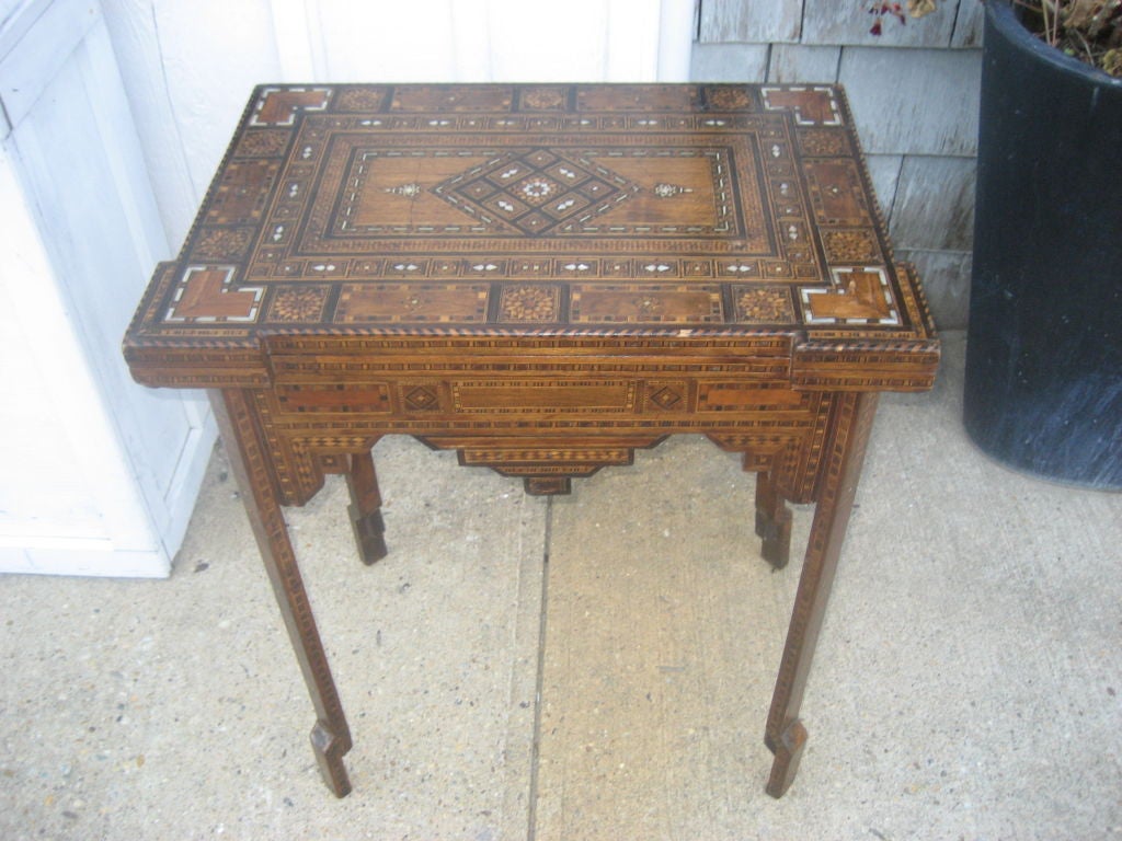 Wonderful and exotic wood and mother of pearl inlaid folding card table with original green felt....makes a great console or side table....