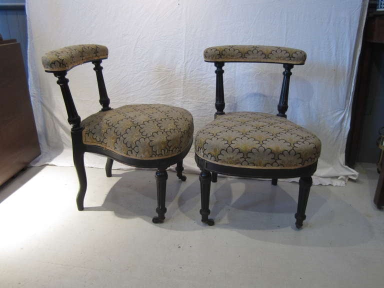 Pair of cock fighting chairs in the style of Napoleon III in their original needlepoint upholstery castors on the back legs.