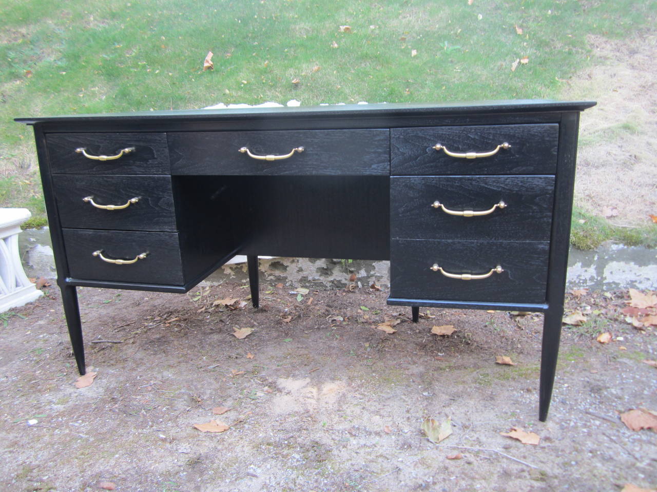 Handsome two-sided desk.....this can float in a room with drawers on one side with brass pulls and a two-tiered book shelf on the other......finished in black satin.....