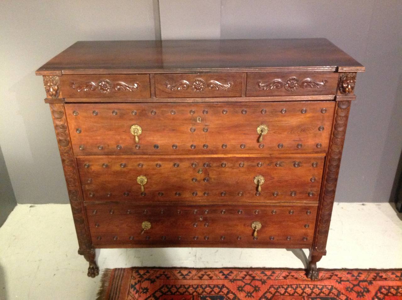 A top quality and very unusual 19th century rosewood chest of drawers with beautiful hand-carved, classical style details, lion's heads, paw feet and rosettes.