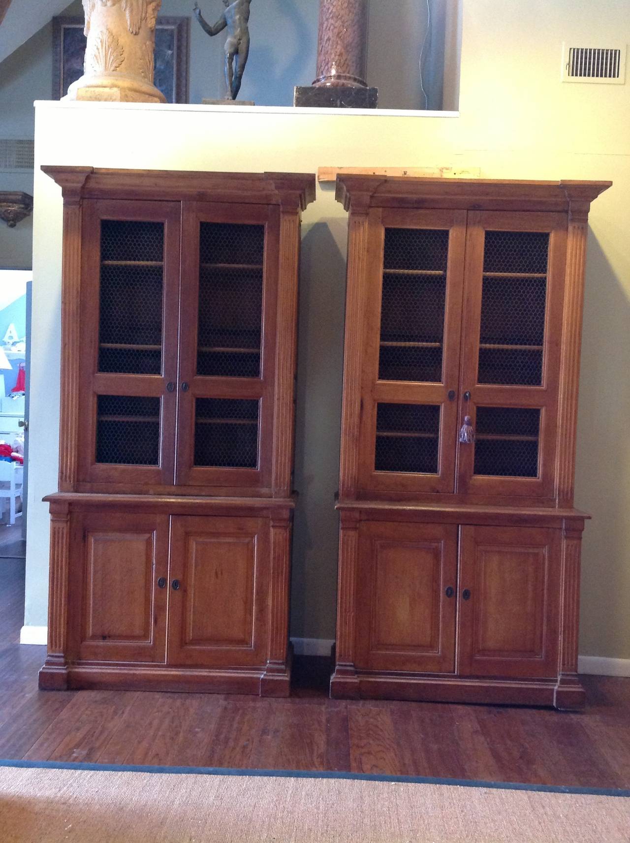 A very handsome and hard to find pair of oak, early 19th century two-part bookcases or display cabinets with original wire doors, and adjustable shelves, on top and bottom.
These cabinets are in very good age appropriate condition and their use can