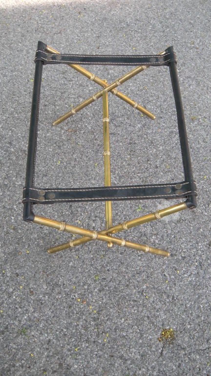 A great quality brass faux bamboo and black leather folding luggage stand attributed to Jacques Adnet circa 1950's. If you will notice , we are not dealers that attribute much...actually nothing . This is a solid attribution from the quality and