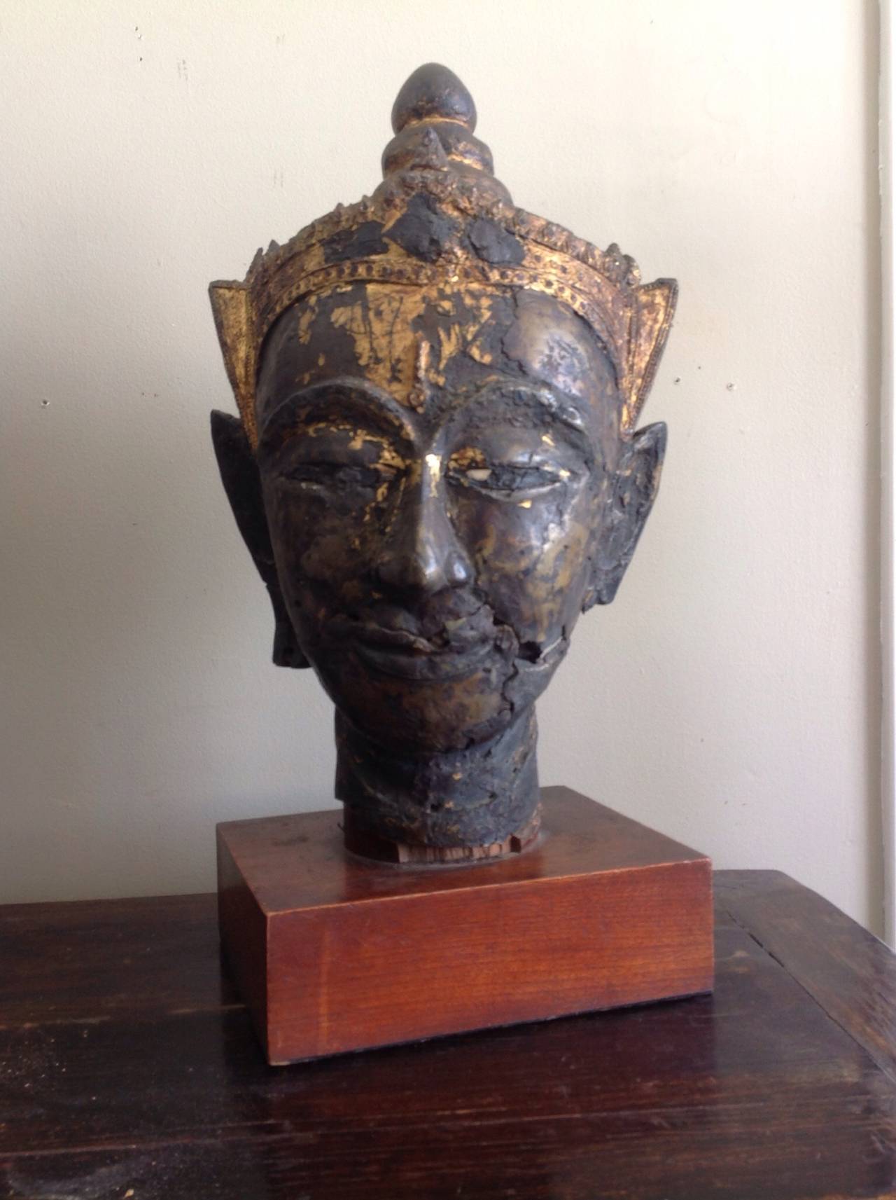 A rare and large Ayutthaya bronze Buddha head from Thailand, possibly Cambodia dating from the 17th century and very probably older. Some traces of original gilding remain on the crown and the Ushnisha. 
The mouth is bow-shaped with a gentle smile,