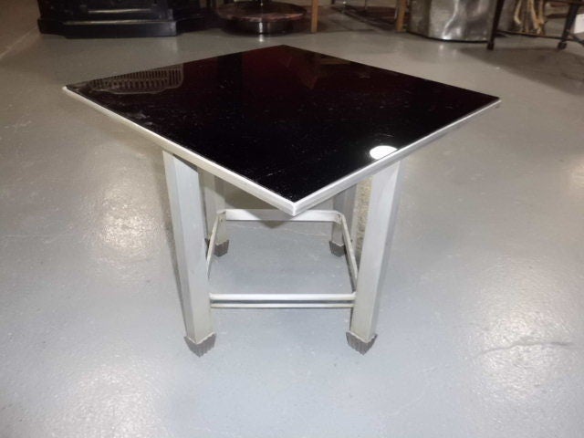 An unusual 1940's/1950's aluminum table with black glass top and brass feet. lots of interesting design detail on this table, from the top, deliberately not in alignment with the feet to the very Art deco looking brass feet. This table is not marked