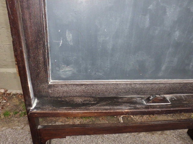 A late 19th ( or very early 20th century at the latest) american free standing, double standing stained oak blackboard, in original condition with a grat 
