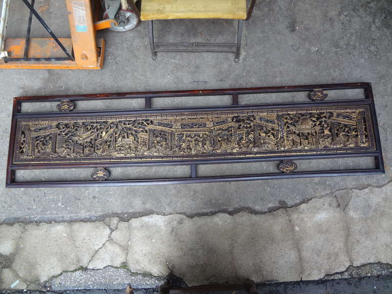 A beautiful 19th century Chinese carved and gilded hardwood panel or frieze depicting a celebration with a central dragon, musicians, pagodas, etc. Wonderfully expressive. Most likely was originally a piece of a temple or an opium bed, something