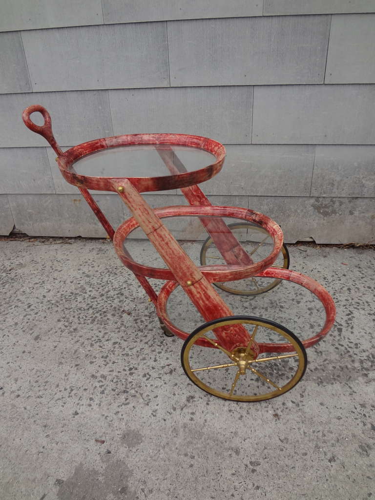 A three-tier Aldo Tura goatskin cart with brass wheels in a gorgeous red color