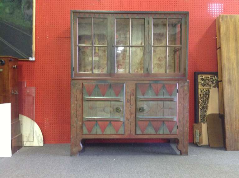 An unusual and beautifully paint-decorated and constructed 2-part cupboard/ cabinet dated 1922. Probably a pantry or dry goods cupboard, in original paint later adapted to a central glass half shelf now missing. We can either remorse the bracket or
