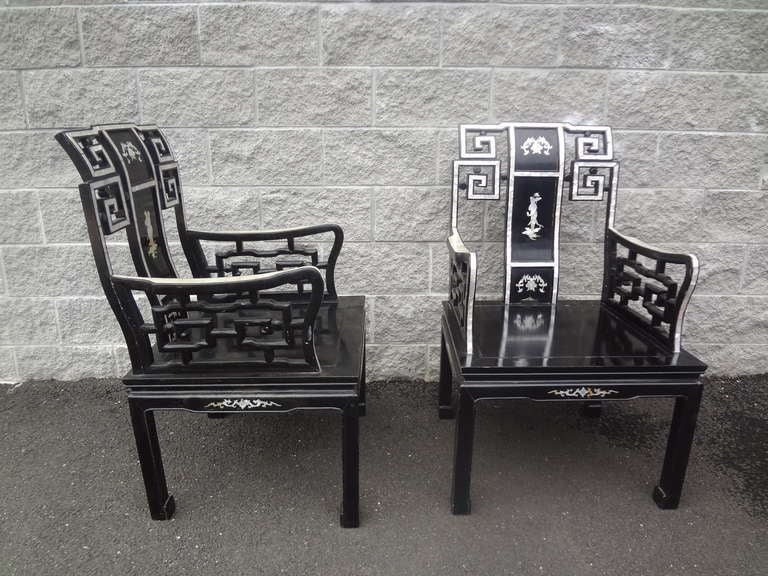 A pair of early 20th century Chinese armchairs with extensive mother-of-pearl inlay decoration in original black paint. The contrast between the black paint and the mother-of-pearl is stunning.