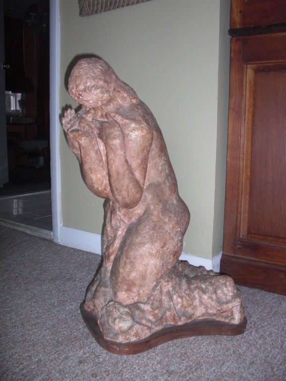 A large and wonderful plaster sculpture on wood base by well listed American sculptor Hugo Robus. Representing a kneeling woman in a moment of surprise , looking down at her own fallen face, lying at her feet. Painted to look like terra-cotta and