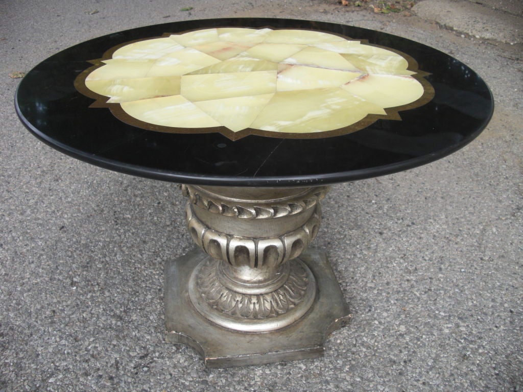 So the carved and silverleaf table is o.k but the marble top is fantastic...black Belgian marble , an inlaid brass band and an onyx center all laid down [ original ] on another piece of white marble making it pretty thick and quite heavy. If you