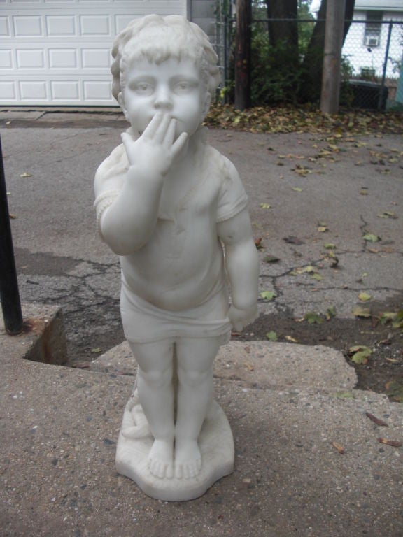 An outstanding and charming carrara marble carving of a little girl in her under garments blowing a (good night?) kiss while leaning against the clothing she just removed. By obscure listed Italian sculptor Angelo Bertozzi and dated 1885, Carrara.