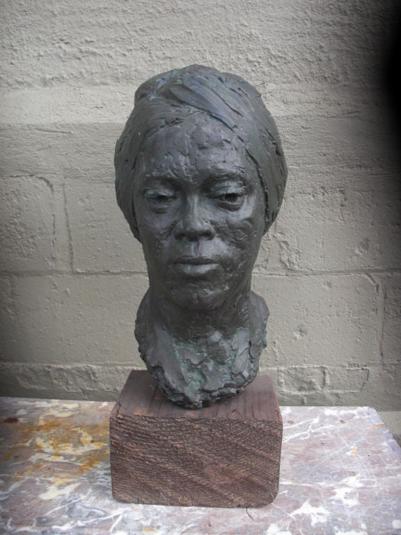 A very competent and insightful portrait bust of an African American woman in a head wrap signed by female sculptor Ruth Millerick and dated 1979. This plaster bust was painted to immitate green / black patinated bronze and sits on its original