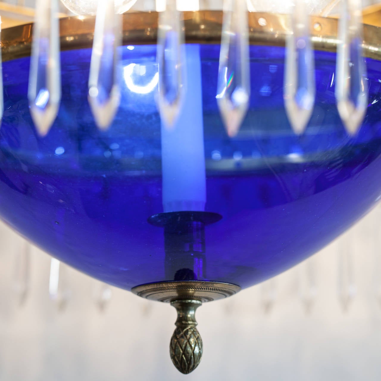 This splendid chandelier in the Gustavian Style has the original cobalt blue hanging basket and blue bobeche. it has six candles around the rim and one candle in the middle of the blue bowl. There are three electric lights in the middle. It has been