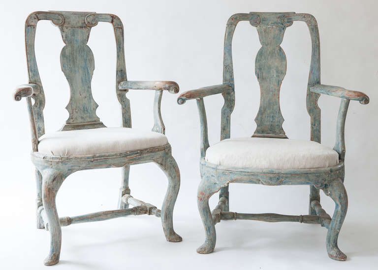 An unusual pair of Swedish Rococo period arms in the original blue paint surface. These are a rare form called Man/Woman chairs because their proportions differ slightly. The man chair is a bit narrower at the back and the woman's chair is wider at