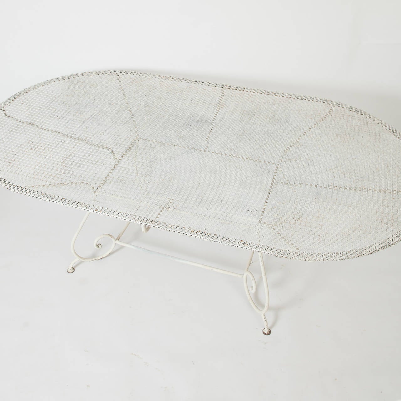 This French garden table is unusual because of it size and versatile oval shape. It can sit eight to ten people comfortably. The scrolled base is recessed to allow lots of leg room. The pierced top is in great condition.